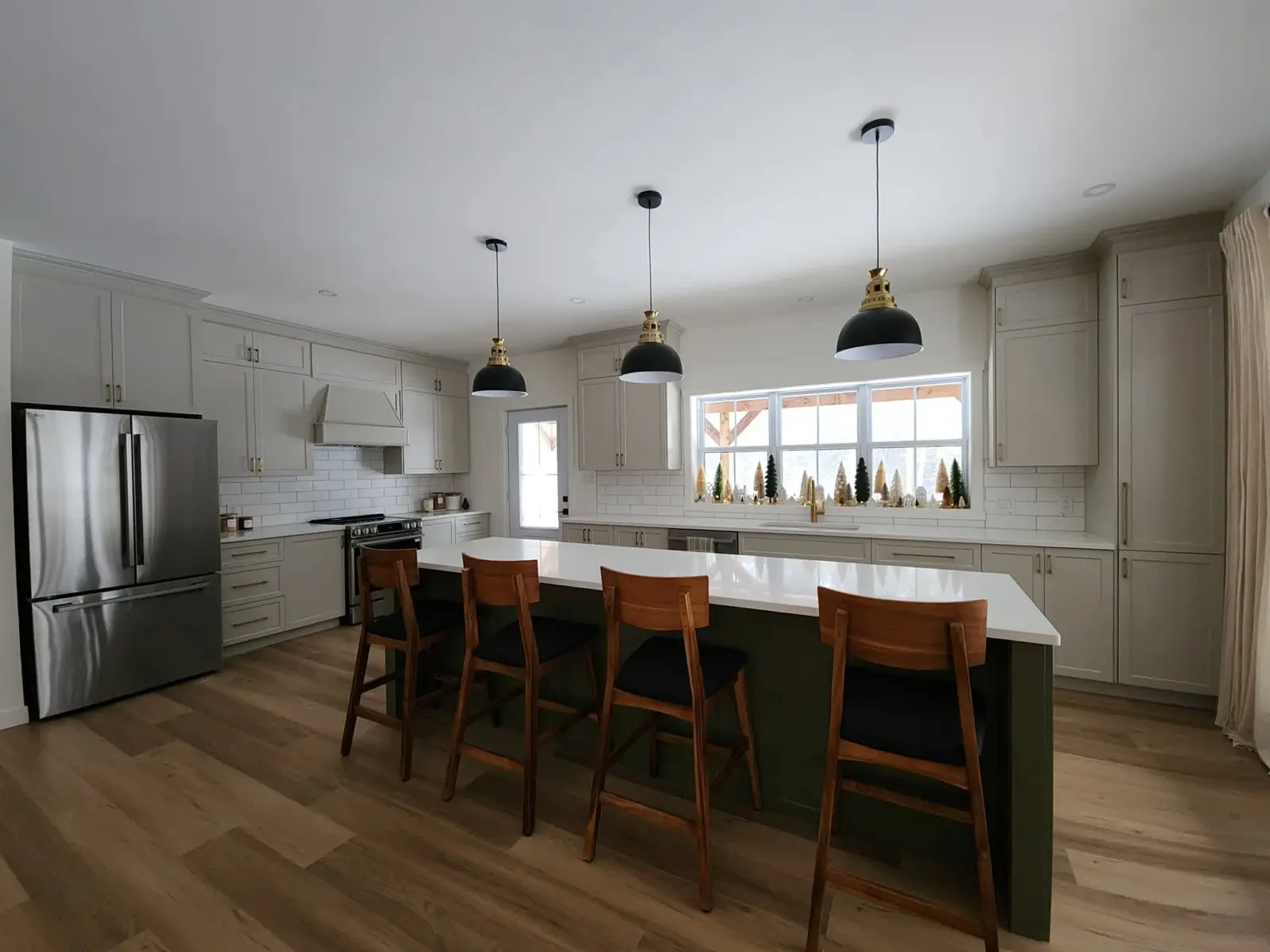White countertop island on a green base with wood stools