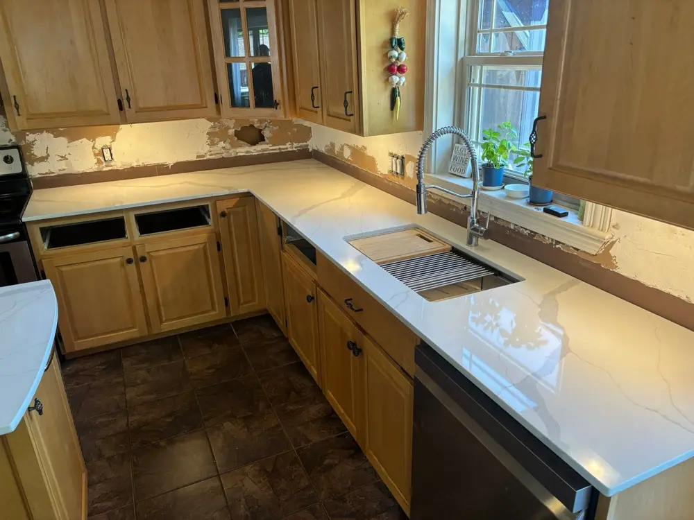 Veined countertop with a workstation sink in an oak kitchen