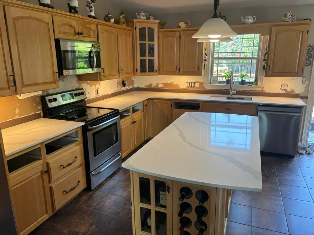 New veined countertops and island in an oak kitchen