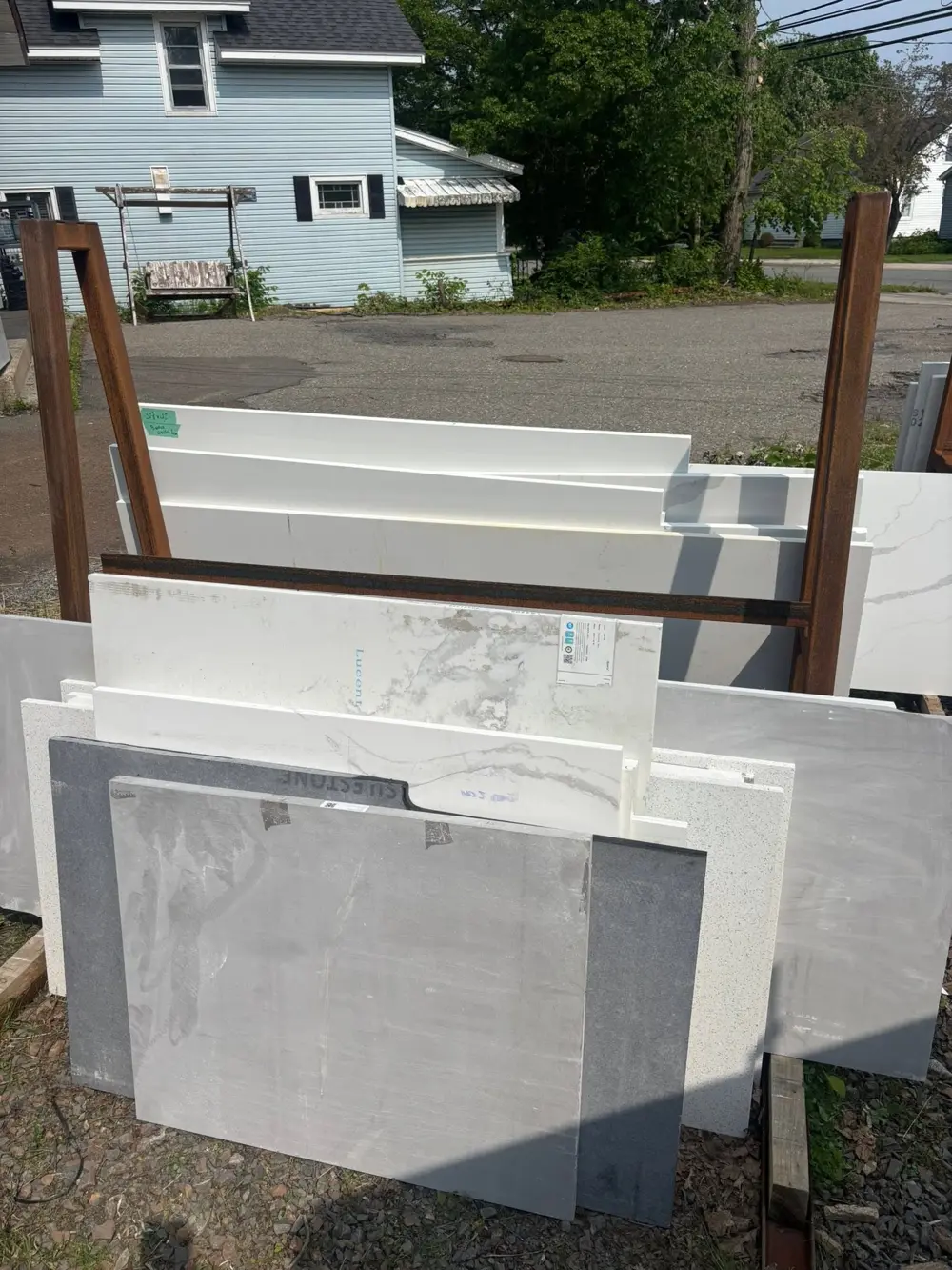 Stone slabs and remnants on a rack outside the shop